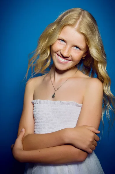 Beautiful blonde girl in a white dress smiling — Stock Photo, Image