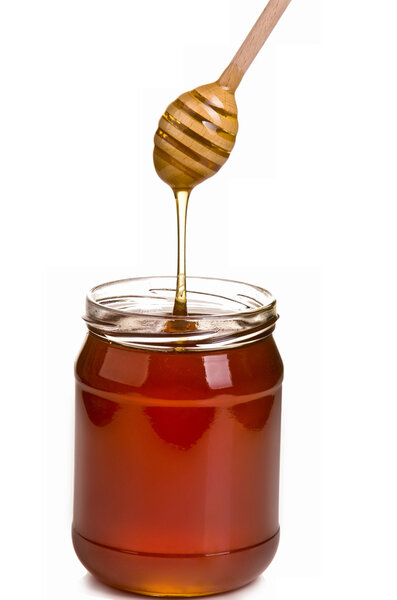 Jar full of honey and stick