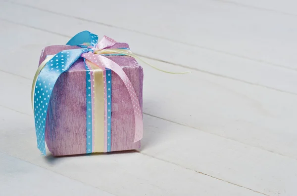 Beautifully wrapped gift in purple paper — Stock Photo, Image