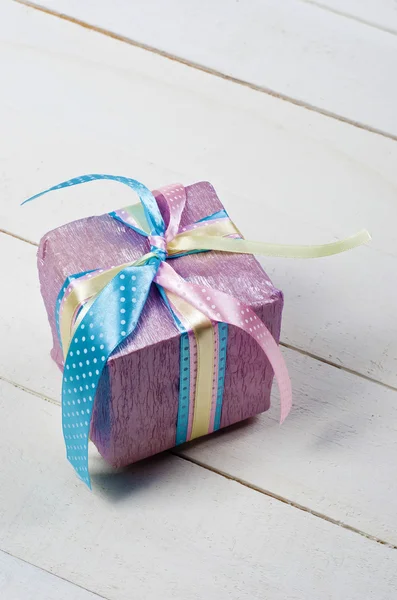 Beautifully wrapped gift in purple paper — Stock Photo, Image