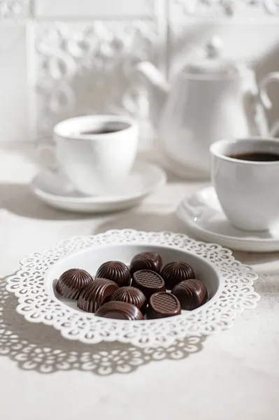 Tea drinking. Tea time. White teapot with cups and a set of chocolates. English breakfast
