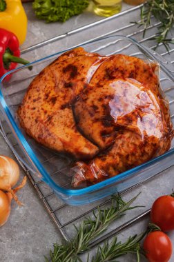 Demir bir tavada cam tepside fırında tavuk eti. Baharatlı ve sebzeli tavuk salamura jambonu (bacaklar).