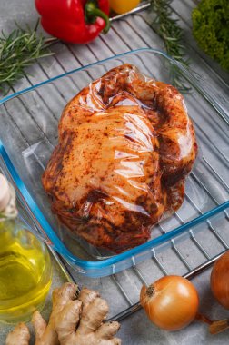 Demir bir tavada cam tepside fırında tavuk eti. Baharatlı ve sebzeli marine edilmiş tavuk leşi..