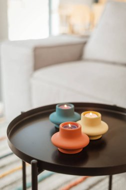 Siyah kahve masasında mumlar olan çok renkli şamdanlar. İskandinav tarzı, rahat ev, dekor elementleri, hyuge