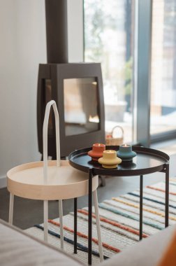 Çok renkli şamdanlar ve şöminenin arka planında siyah bir sehpanın üzerinde mumlar. İskandinav tarzı, rahat ev, dekor elementleri, hyuge