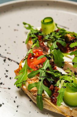 Domatesli bruschetta, yumuşak peynir, roka ve güneşte kurutulmuş domates. Bir gurme için hafif bir atıştırmalık. İtalyan mutfağı