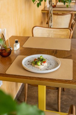 Sıcak ahşap bir masada domates, yumuşak peynir, roka ve güneşte kurutulmuş domatesle iştah açıcı bruschetta. Bir gurme için hafif bir atıştırmalık. İtalyan mutfağı