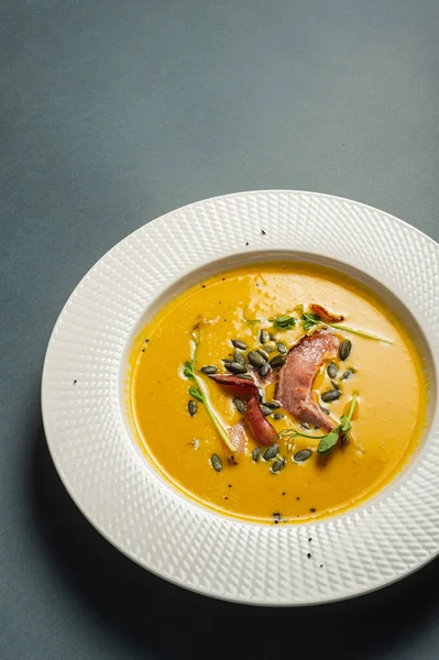 南瓜汤 咸肉配豌豆种子 芽插在漂亮的白盘里 简单健康的营养食品 在餐馆里享用自制的饭菜 — 图库照片