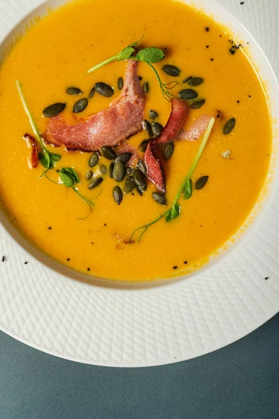 南瓜汤 咸肉配豌豆种子 芽插在漂亮的白盘里 简单健康的营养食品 在餐馆里享用自制的饭菜 — 图库照片