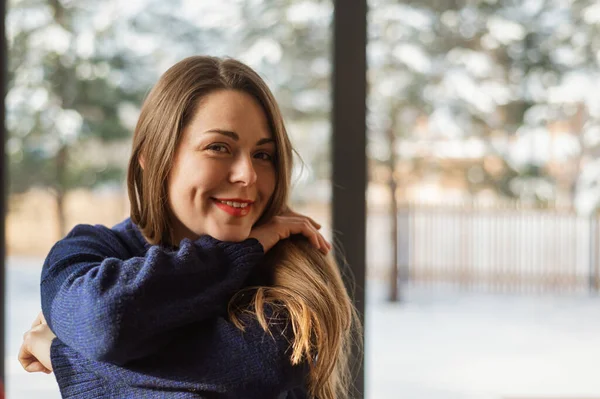 穿着保暖针织西服 穿着私家 理发店 的时髦女人 冬季在全景窗后面 窗外美丽的雪天 斯堪的纳维亚风格 乡村别墅里的寒假 斯堪的纳维亚人广阔的内陆 — 图库照片