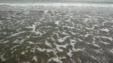 İtalya 'nın güney kıyısı, Salerno. Güneşli bir bahar günü, kumlu sahilde deniz dalgaları. Güzel, sakin bir deniz. Ufuktaki dağlar