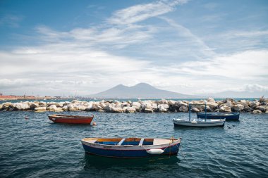 Sakin mavi Tyrhenian Denizi. Napoli 'nin setinden Vezüv Dağı yanardağına bakın. Kıyıya ve taştan dalgakıranlara demirlemiş eğlence tekneleri. Meditasyon için güzel manzara