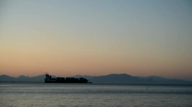 Sabahın erken saatlerinde, deniz ve kayaların üzerinde şafak vakti. Kuru kargo gemisi Salerno limanından yola çıkıyor. Vietri şehri. Amalfi Sahili, Güney İtalya