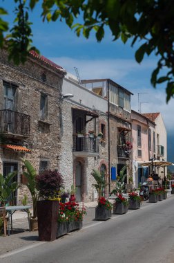 Güney İtalya 'da ortaçağ caddesi. Paestum şehri. Kırmızı sardunyaları olan güneşli güzel bir cadde.