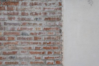 Tarihi bir evin eski tuğla duvarı. Bazen aşınmış tuğla, aşınma izleri, rüzgar ve su. Çok şey gören duvarlar. Doku, arkaplan