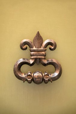 Vintage metal doorknob knocker gong on an old door