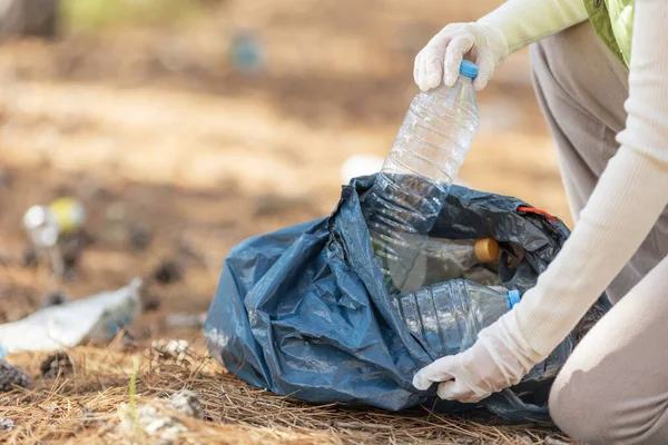 Bir kadın doğadaki çöpleri temizler..