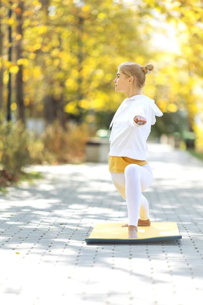 La mujer practica yoga en el parque. Chica en los deportes. — Foto de Stock