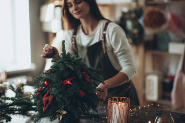 Bir kadın kendi elleriyle Noel ağacı yapar..
