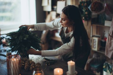 Bir kadın kendi elleriyle Noel ağacı yapar..