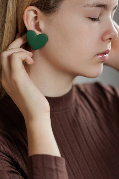 Девочка-подросток выбирает ювелирные серьги. Сердечные серьги. День Святого Валентина.