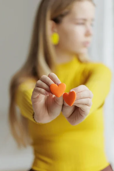 Adolescente chica elige pendientes de joyería. Pendientes en forma de corazón. Día de San Valentín. — Foto de Stock