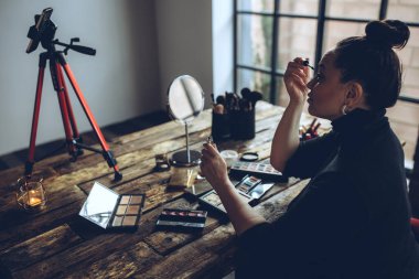 Makyaj yapan bir kadın yaşar.