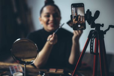 Makyaj yapan bir kadın yaşar.