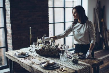 Masa ayarı. Kadın masayı süslüyor..