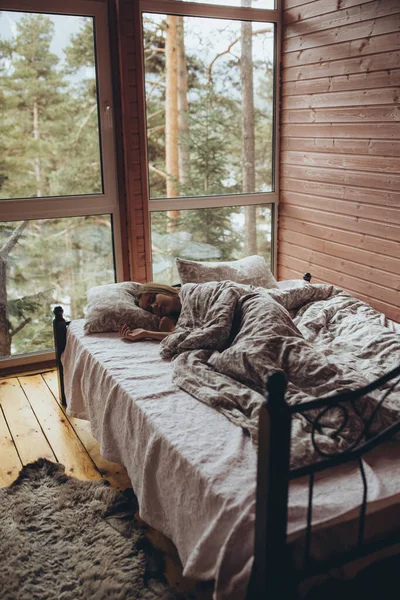 La chica está durmiendo en la cama. Una chica joven y hermosa duerme con una hermosa vista desde la ventana. — Foto de Stock
