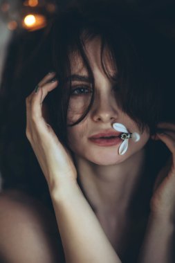 Çiçekli bir kadının portresi. Güzel bir kız yüzüne bir kartopu çiçeği tutar..