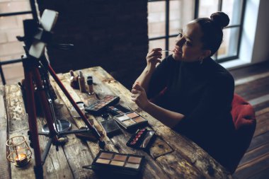 Makyaj yapan bir kadın yaşar.