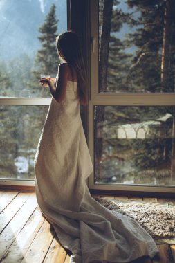 Güzel kız doğaya tepeden bakan evinde çay içiyor..