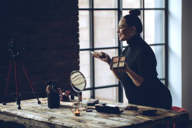 Makyaj yapan bir kadın yaşar.