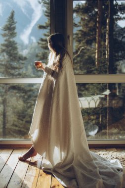 Güzel kız doğaya tepeden bakan evinde çay içiyor..