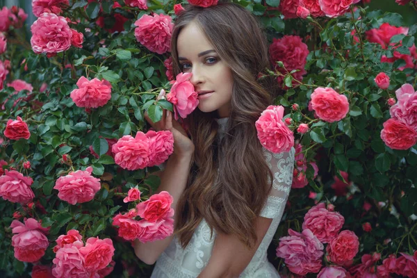 Vrouw in rozen op de natuur. — Stockfoto