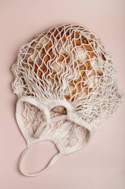 Ekmekli pamuklu örgü alışveriş torbası. Taze fırın. Naylon yoksa ziyan da yok. Bej arkaplan.