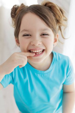 Çocuk bir dişini kaybetti. Dişsiz bebek. Dişi olmayan küçük bir kızın portresi..