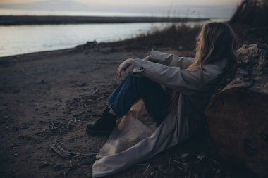 Gün batımında deniz kenarında güzel bir genç kız.