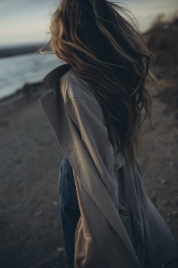 Gün batımında deniz kenarında güzel bir genç kız.