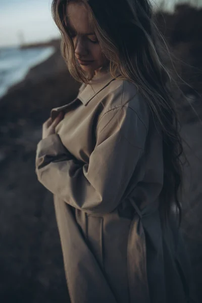 Hermosa joven al atardecer junto al mar. — Foto de Stock