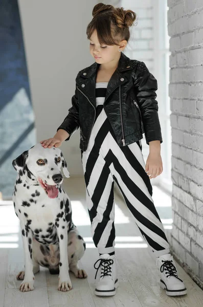 Niños de moda. Niña con un perro posando en ropa de moda. — Foto de Stock