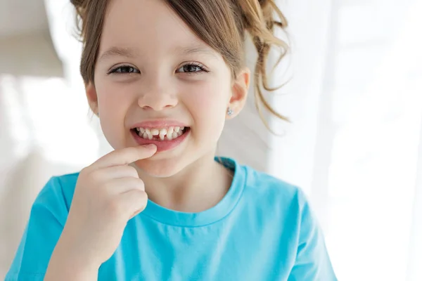 The kid lost a tooth. Baby without a tooth. Portrait of a little girl no tooth.