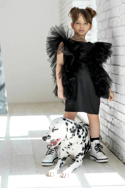 패션 아이들. 유행하는 옷을 입은 개를 데리고 있는 어린 소녀. — 스톡 사진