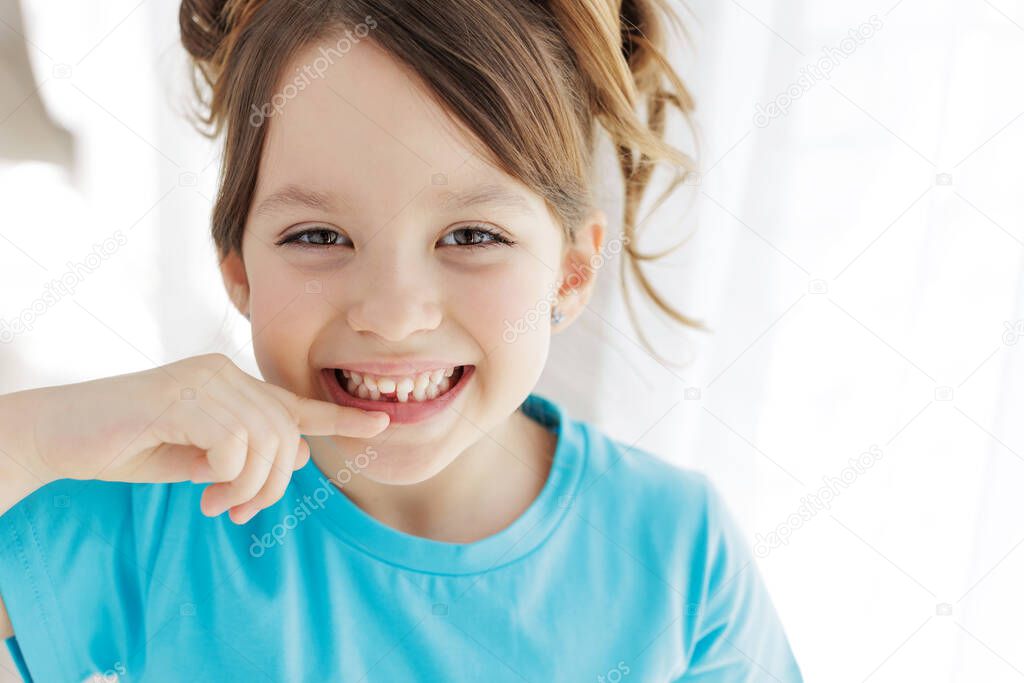 The kid lost a tooth. Baby without a tooth. Portrait of a little girl no tooth.