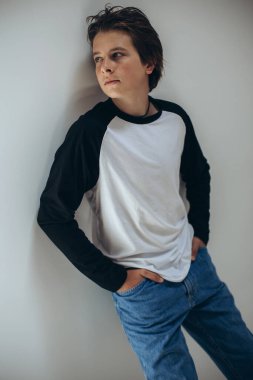 Portrait of a handsome teenage boy posing against a white background. Studio shot. Teenage fashion.