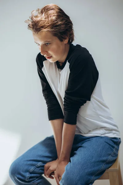 Πορτρέτο ενός όμορφου έφηβου αγοριού που ποζάρει πάνω σε λευκό φόντο. Στιγμιότυπο. Εφηβική μόδα. — Φωτογραφία Αρχείου