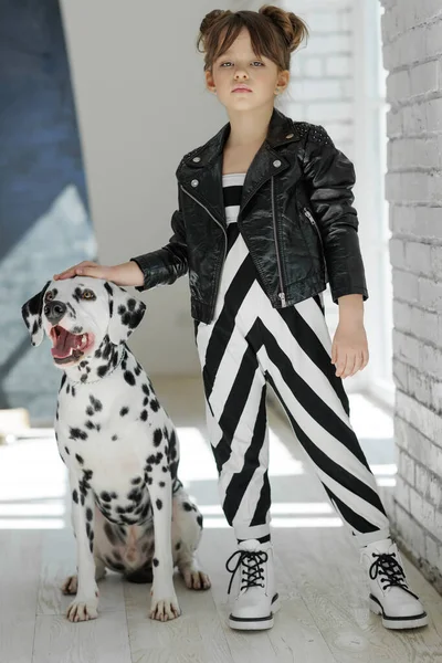 패션 아이들. 유행하는 옷을 입은 개를 데리고 있는 어린 소녀. — 스톡 사진