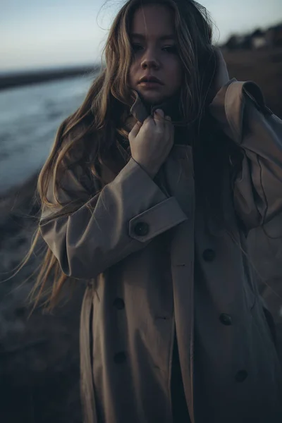 Hermosa joven al atardecer junto al mar. — Foto de Stock