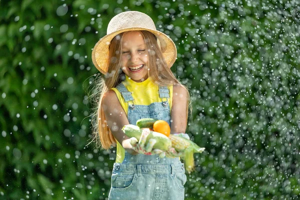 Child with vegetables. Happy little girl holding vegetables in her hands. High quality photo